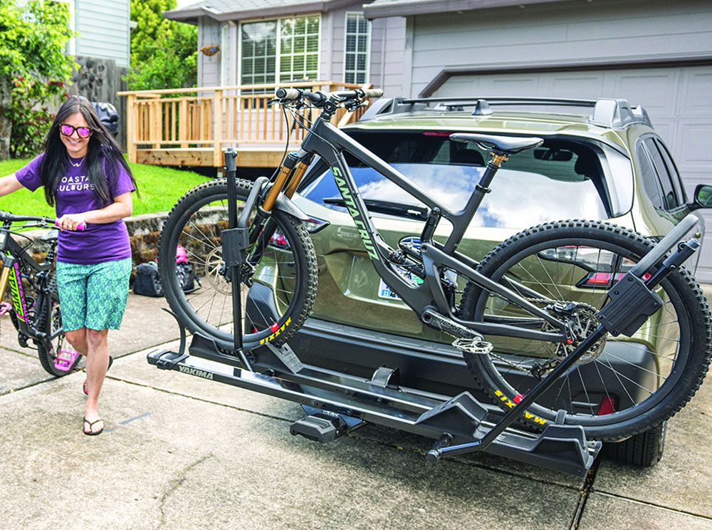 A woman about to load a bike on a hitch-mounted bike rack
